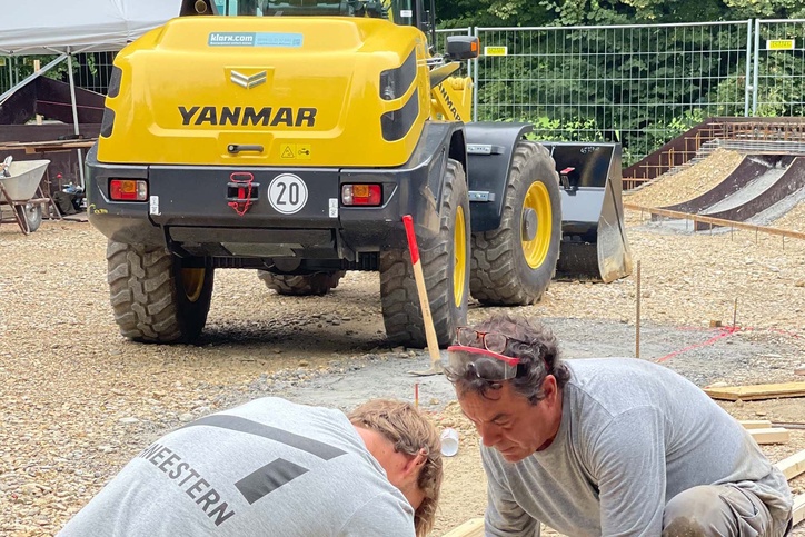 Schneestern Mitarbeiter und klarx Baumaschine beim Bau von Skatepark Hirschgarten