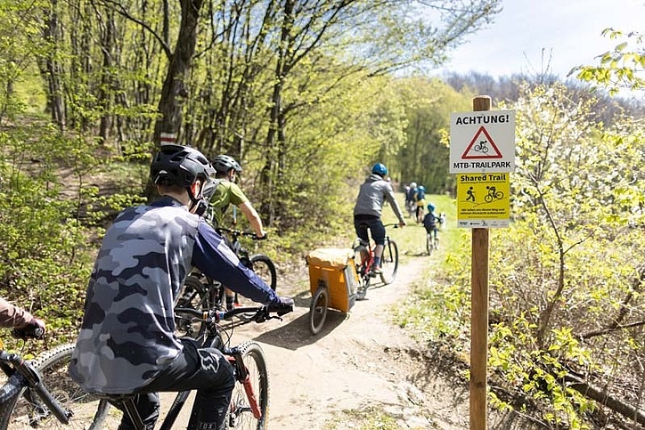 Mixed group of cyclists passes sign