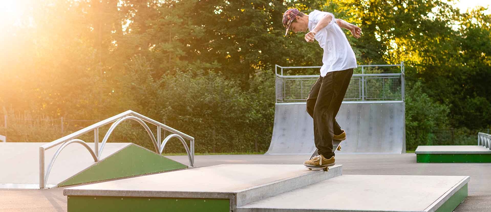 Sonnenuntergang über dem Rampenpark Isny mit Skatern auf den Obstacles