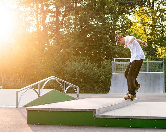 Sunset over Rampenpark Isny with skaters on the obstacles