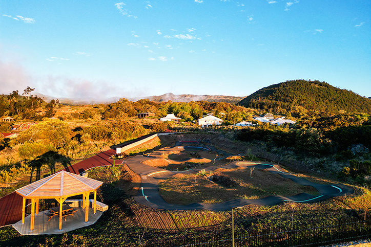 Close-up of a pump track berm in Le Tampon with a scenic mountain backdrop.