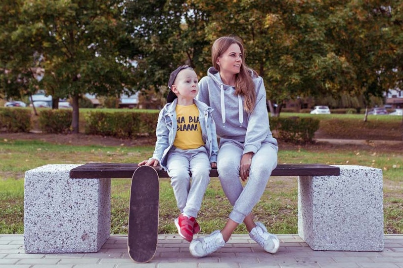 Young mother sitting with child on a park bench