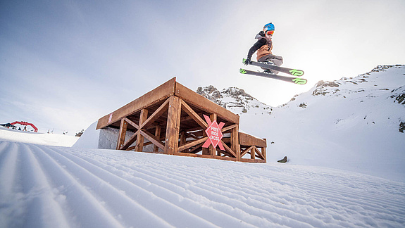 Skifahrer springt über Wooddrop im Freeride Cross Montafon