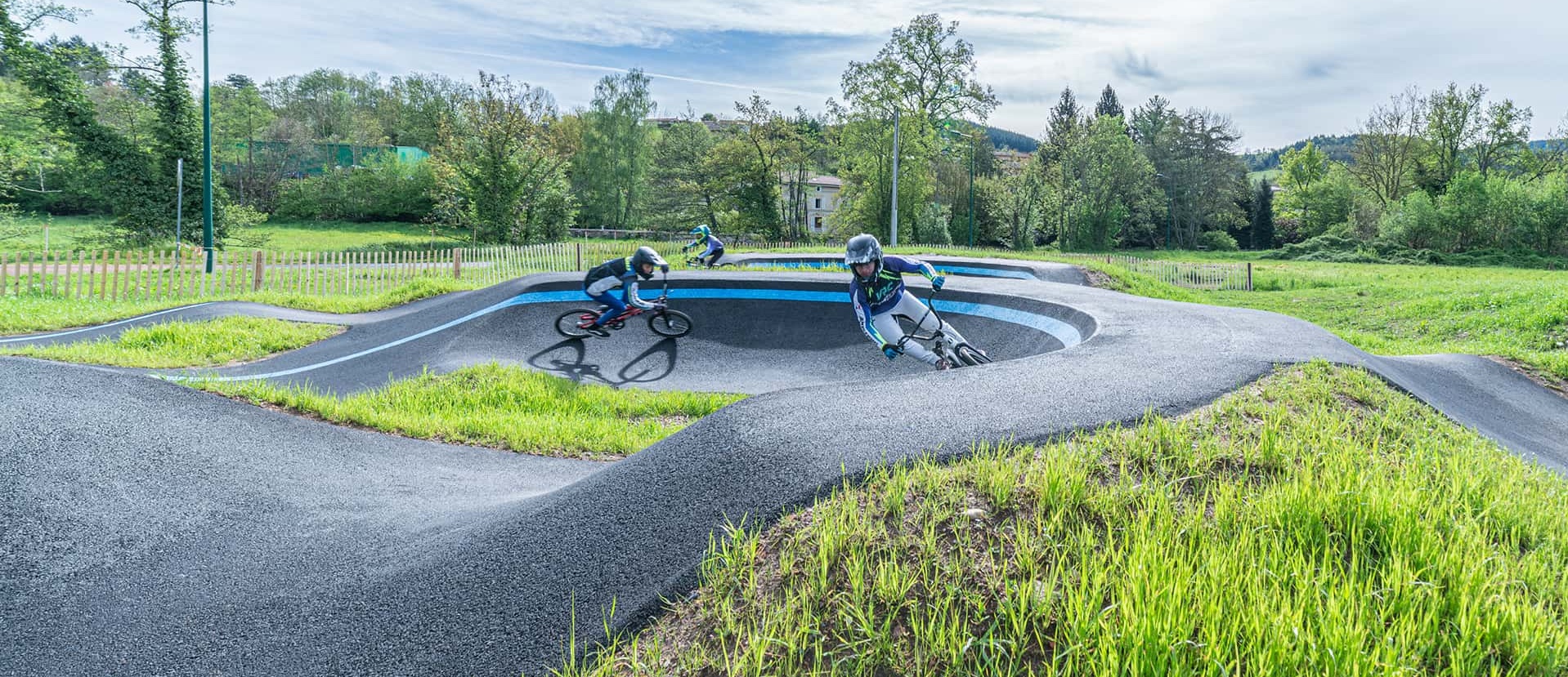Plusieurs vététistes et pilotes de BMX profitent des courbes et des bosses du pumptrack de Cublize.