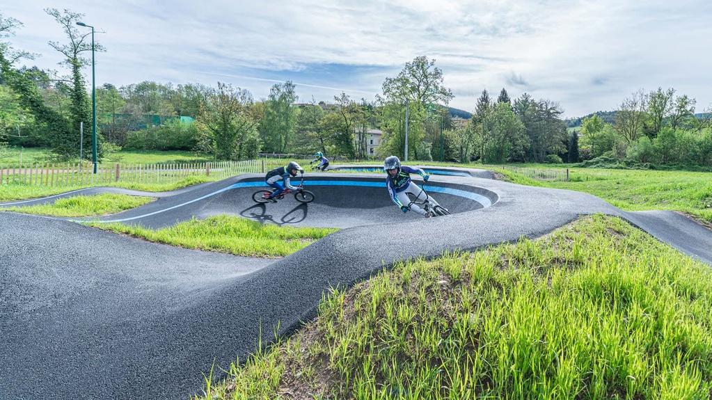 Plusieurs vététistes et pilotes de BMX profitent des courbes et des bosses du pumptrack de Cublize.