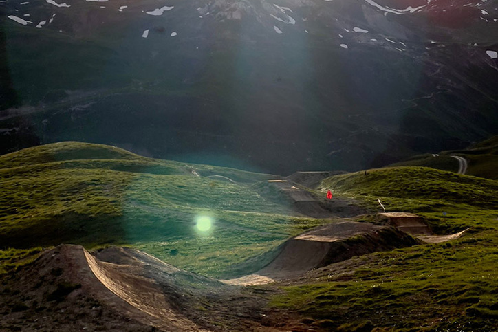 Trail du Bike Park Tignes au coucher du soleil avec chaîne de montagnes en arrière-plan