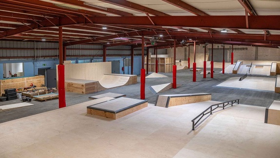 Gesamtansicht der Indoor-Skatehalle Fürth mit verschiedenen Rampen und Hindernissen