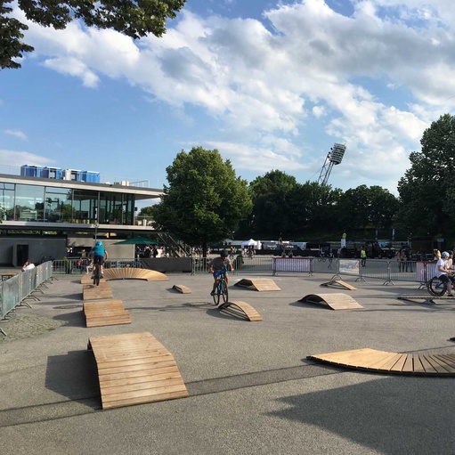 [Translate to Chinesisch:] Various exercise elements on an asphalt square with trees