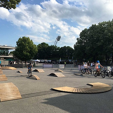 [Translate to Chinesisch:] Various exercise elements on an asphalt square with trees