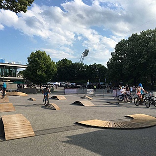 Various exercise elements on an asphalt square with trees