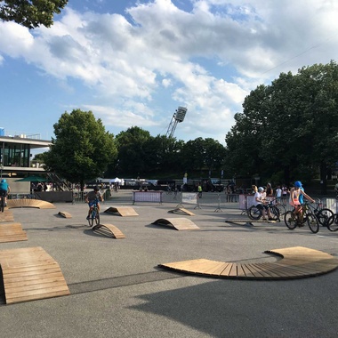 Various exercise elements on an asphalt square with trees