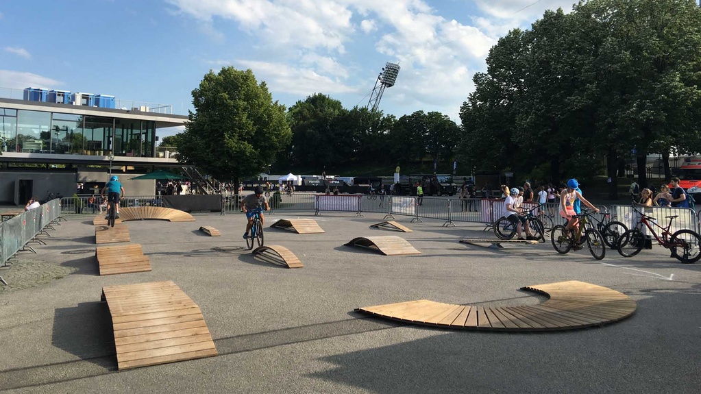 Various exercise elements on an asphalt square with trees