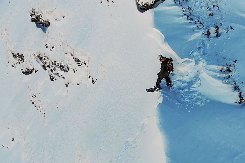 Snowboarder on a snow covered mountain top before start skiing