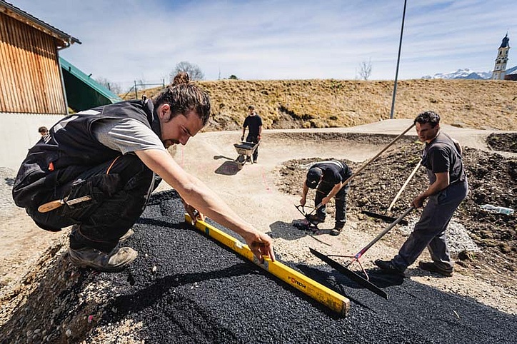 [Translate to Französisch:] Men flatten fresh asphalt in nice weather