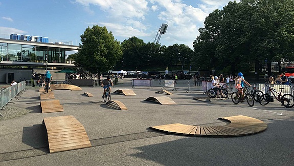 Various skills obstacles on an asphalt square with trees