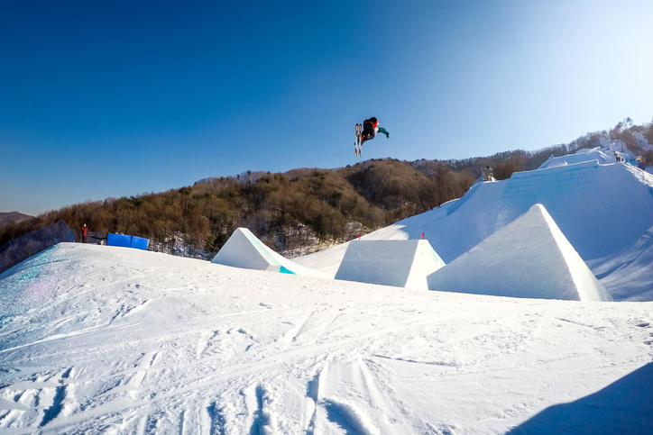 Skier jumps from above and is in the air