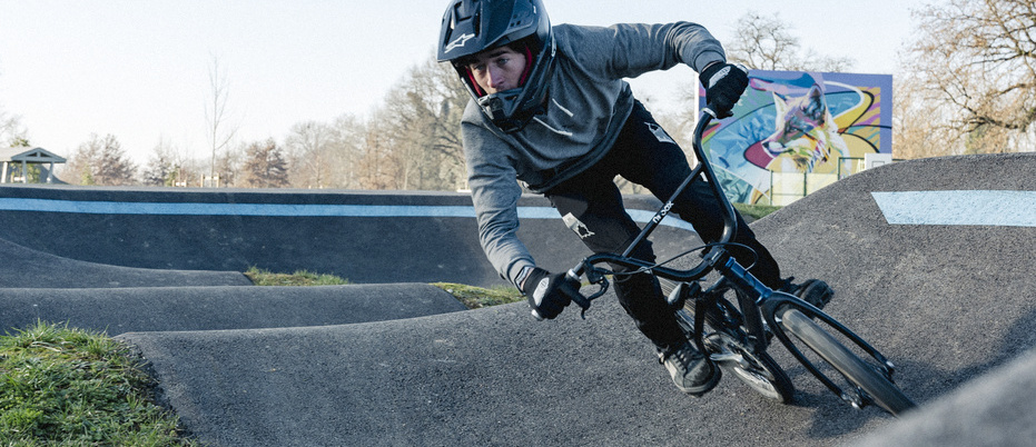 Cycliste BMX avec casque en action sur la piste de pumptrack
