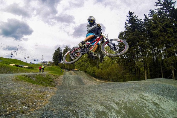Biker jumps towards camera and lift in the background