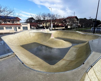 Panoramic wide shot of the empty concrete skatepark in Biscarrosse after rain.