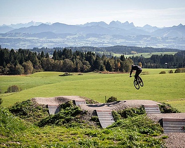 Mountainbiker springt mit Panorama im Hintergrund