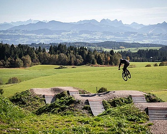 Mountainbiker springt mit Panorama im Hintergrund