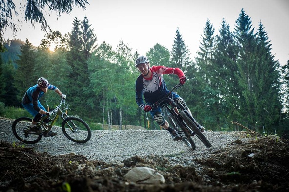 Zwei Biker in einer Kurve am Waldrand