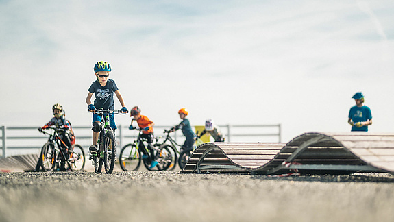 Kinder trainieren mit Mountainbikes und Übungselementen