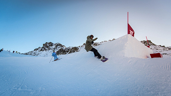 Snowboarder und Skifahrer fahren in Anliegerkurve