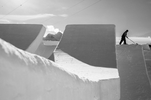 Schwarz-Weiß-Aufnahme eines Shapers beim Feinschliff eines Swatch Snowpark Kickers am Schilthorn.