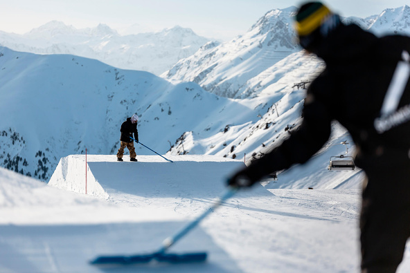Schneestern employees shaping with snow covered mountains in the background