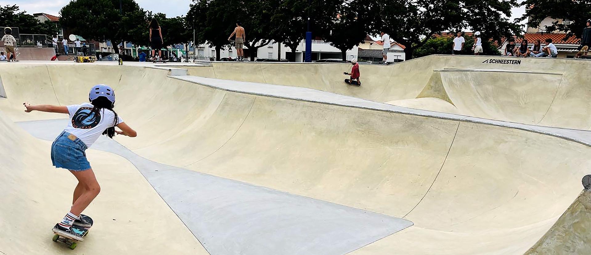 Skatepark de Biscarrosse animé avec plusieurs skateurs profitant des installations en béton.