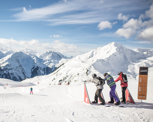 Three skiers are at the start gates and ready to go