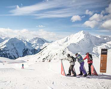 Drei Skifahrer stehen an Startgates und sind bereit loszufahren