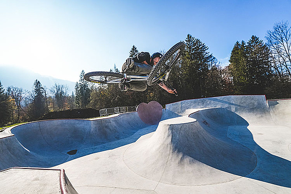 Mountainbiker springt über die geschwungenen Lines im Skatepark Samoëns.