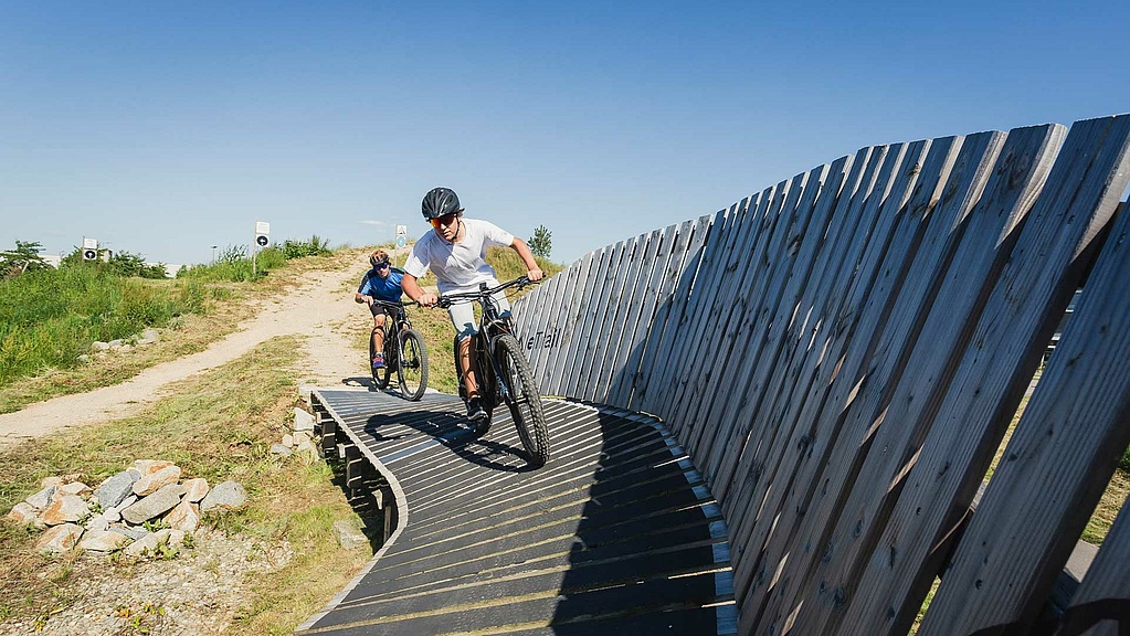 E-bike trail with artificial curve and two e-bikers