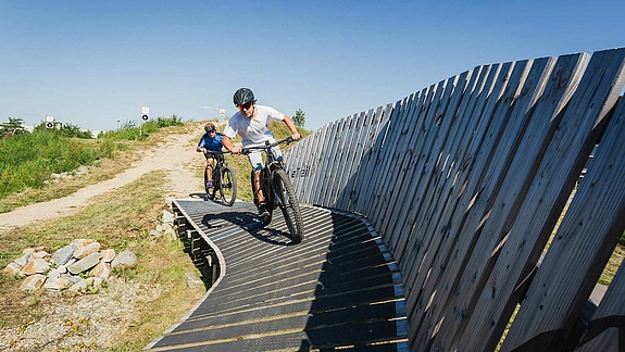 E-bike trail with artificial curve and two e-bikers