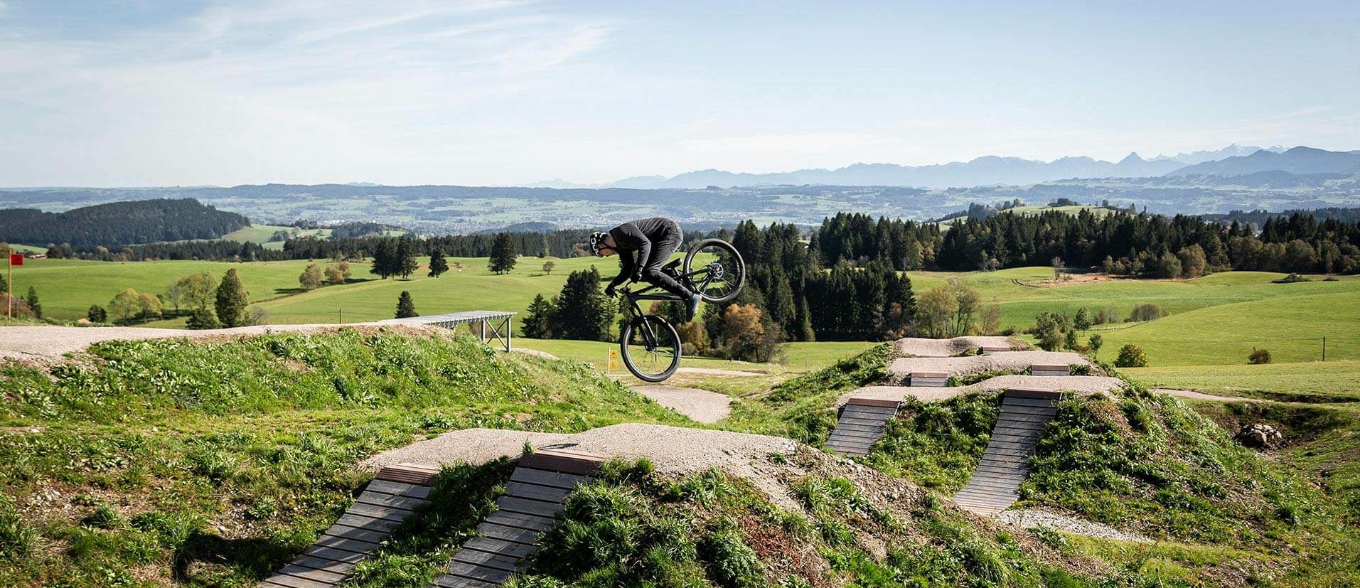 Mountain biker jumps in front of Panorama mountain