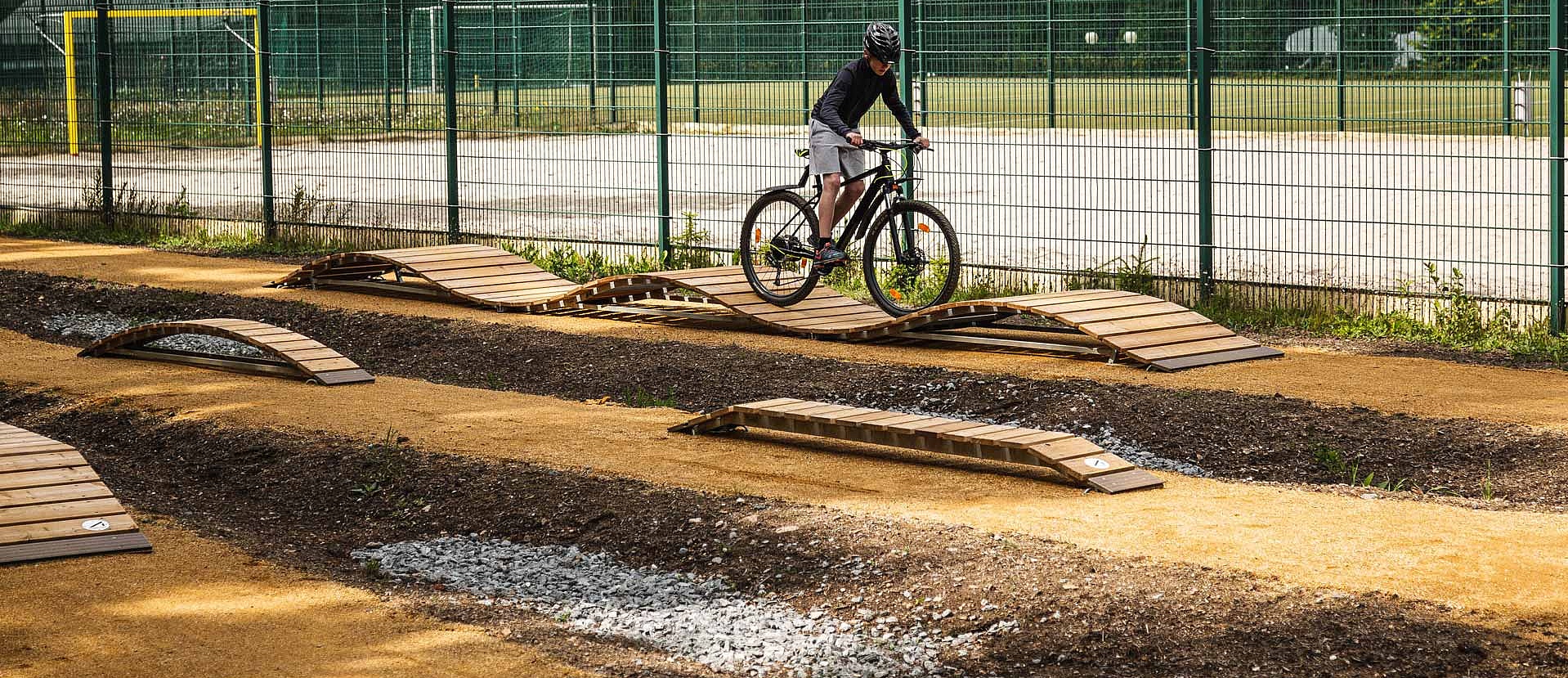 Rider testing wooden elements on skills course at MTB Park Rabenberg