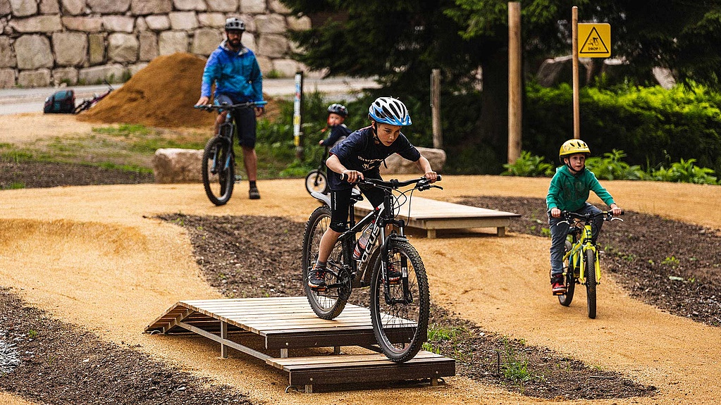 Young mountain bikers practicing drops and features at MTB Park Rabenberg