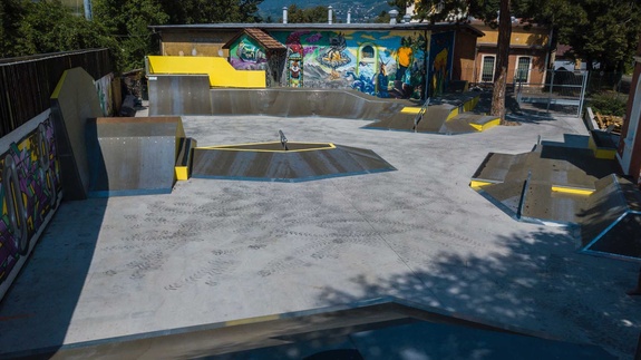 Wide-angle shot showing the diverse concrete and timber ramp setups at Meran skatepark.