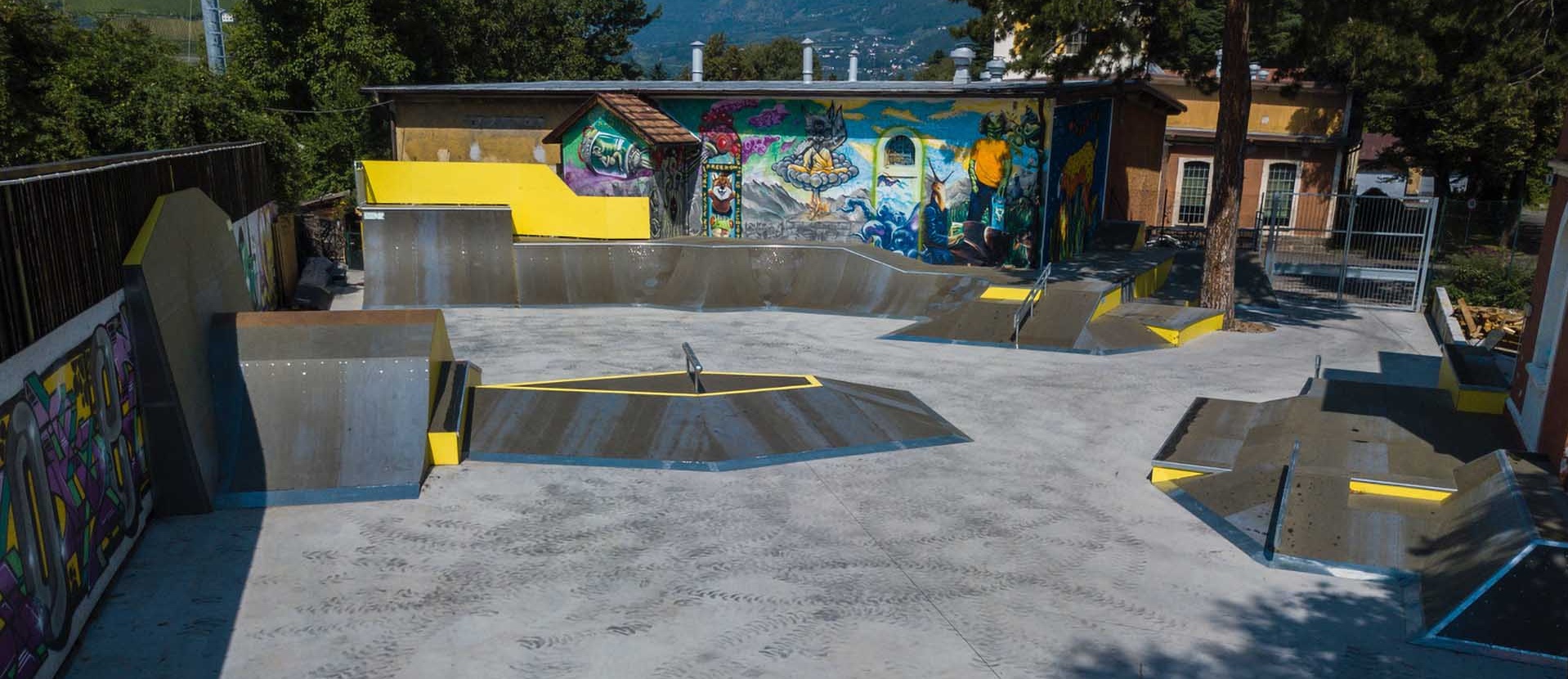 Weitwinkelaufnahme der verschiedenen Beton- und Holzrampen des Skateparks Meran.