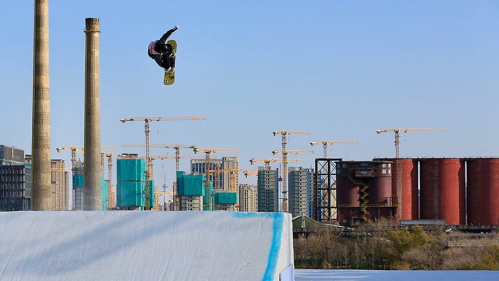 Snowboarder in front of building cranes in the Big Air Sprung