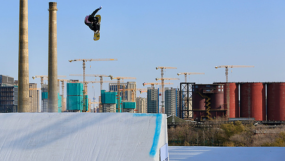 Snowboarder in front of building cranes in the Big Air Sprung