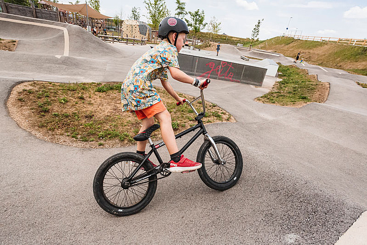 Junge fährt mit Rad auf dem Pumptrack
