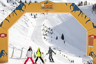 Three skiers ski through slope on arch