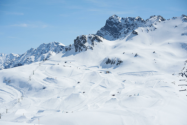Blick auf den gesamten Snowpark mit Bergkette