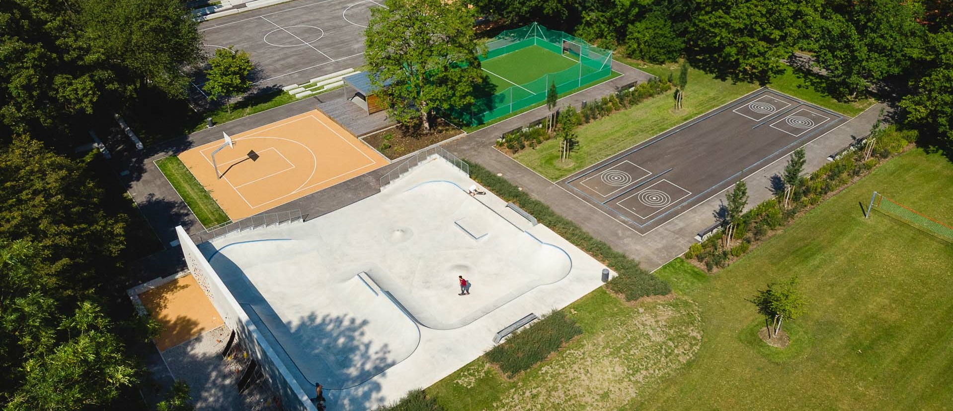 Drone image of skate park and sports fields surrounded by meadow and trees