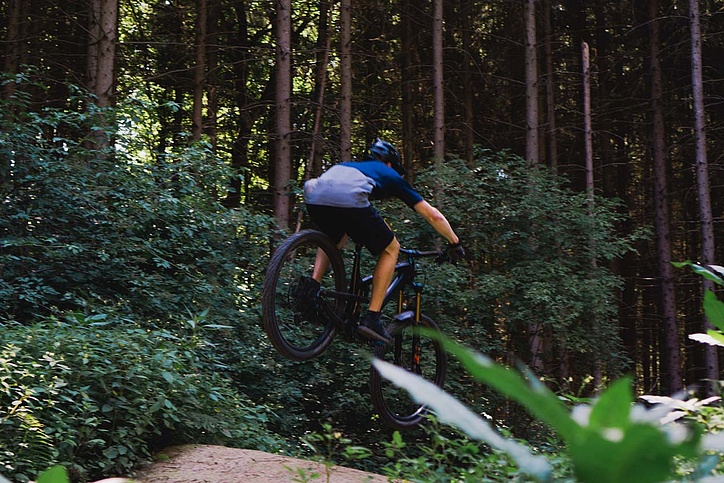 Mountain biker jumps over ramp