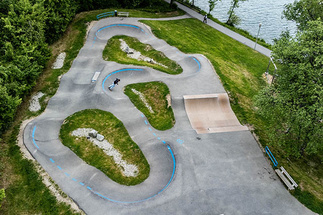 Pumptrack Wackersberg als Luftaufnahme am Seeufer mit asphaltierten Kurven und Wellen