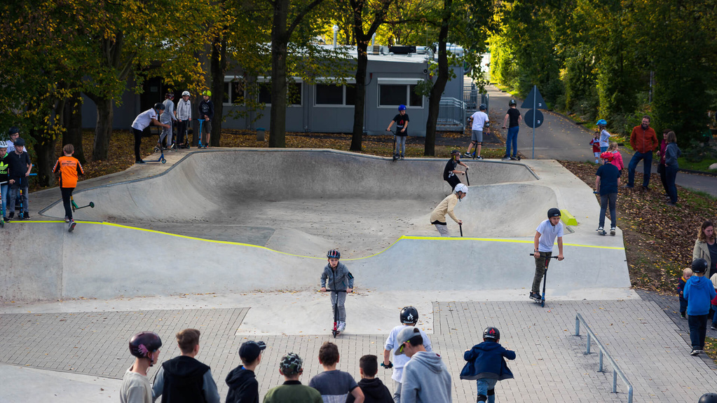 Kids ride in skate park Hennef and other kids watch